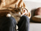 long-haired brown-and-white tabby cat sat on someone's lap and being stroked