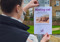 A woman sticking a missing cat poster to a post